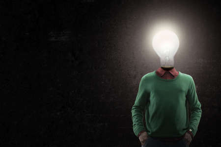 Great mentality. Male body of model with bright electric bulb instead head isolated on black background. Modern design. Contemporary art collage. Inspiration, mood, creativity, brain conceptの写真素材