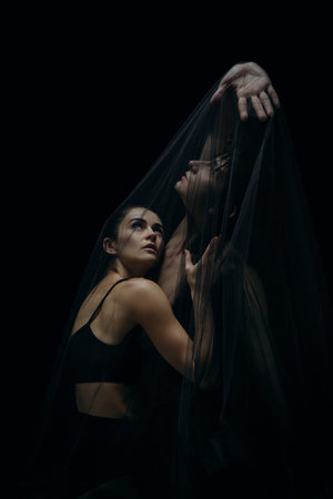Skin. Graceful classic ballet dancers isolated on black studio background. Couple in minimalistic dark cloth look graceful, inspired. The grace, artist, movement, action and motion concept.の写真素材