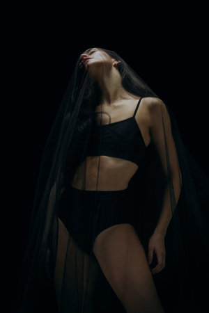 Dreams. Graceful classic female ballet dancer isolated on black studio background. Woman in...