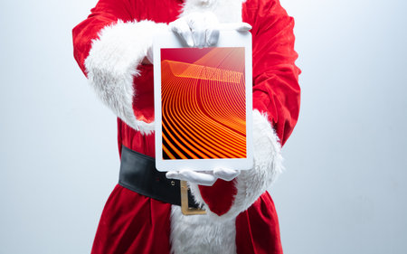 Close up hands of Santa Claus holding device with neoned decoration on the screen. Concept of winter...