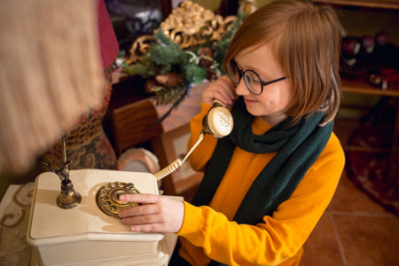 Old phone talks. Cheerful little blonde boy looking for home decoration and holidays gifts in household store. Stylish retro things for greetings or design. Interior renovation, celebrating time.の写真素材