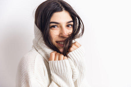 Wrapping. Portrait of beautiful brunette woman in comfortable soft longsleeve isolated on white...