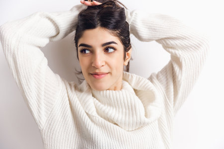Cozy. Portrait of beautiful brunette woman in comfortable soft longsleeve isolated on white studio...