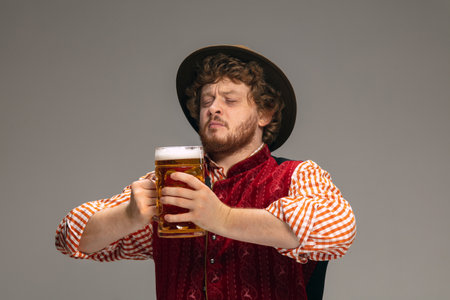Fun. Happy man dressed in traditional Austrian or Bavarian costume gesturing with mug of beer on...