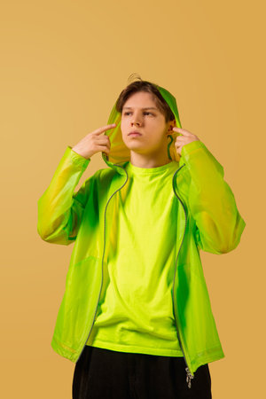 Cool. Old-school fashioned young man dancing isolated on yellow studio background. Artist fashion, motion and action concept, youth culture, fashion returning. Young caucasian curly boy.の写真素材