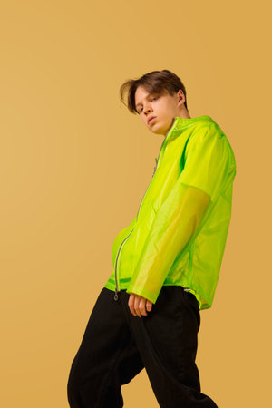Cool. Old-school fashioned young man dancing isolated on yellow studio background. Artist fashion,...