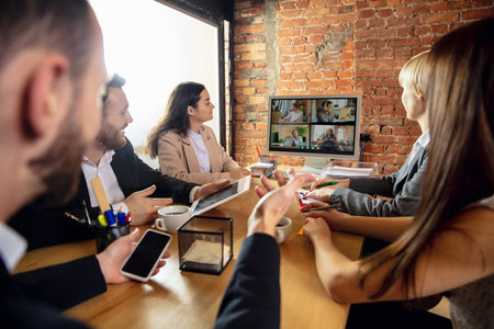 Team. Young people talking, working in videoconference with colleagues, co-workers at office or living room. Online business, education during insulation, quarantine. Work, finance, tech concept.の写真素材