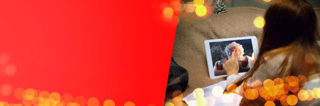 Wishlist. Happy caucasian little girl during video call with Santa Claus on the laptops screen and home devices, looks dreamful. Celebration or ad flyer with copyspace. New 2021 Year meeting.の写真素材