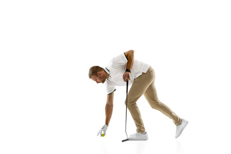 Prepares. Golf player in a white shirt practicing, playing isolated on white studio background with copyspace. Professional player practicing with bright emotions and facial expression. Sport concept.の写真素材