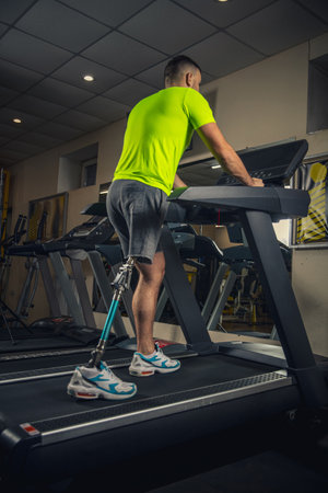 Athletic. Disabled man training in the gym of rehabilitation center, practicing. Active man with...