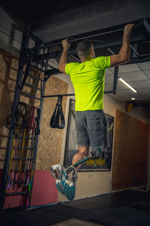 Energy. Disabled man training in the gym of rehabilitation center, practicing. Active man with...