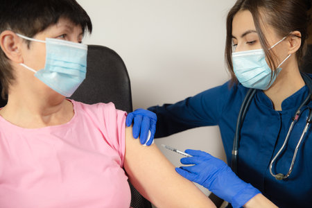 Close up doctor or nurse giving vaccine to patient using the syringe injected.の写真素材