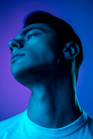 Icon. Handsome caucasian mans portrait isolated on purple studio background in neon, monochrome....