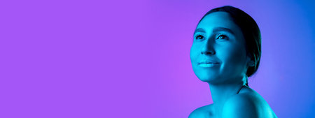 Flyer. Beautiful east womans portrait isolated on gradient studio background in neon, monochrome. Female brunette model. Concept of human emotions, facial expression, sales, ad, fashion and beauty.の写真素材