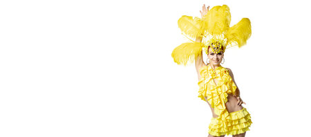Smiling. Beautiful young woman in carnival masquerade costume with yellow feathers dancing on white...