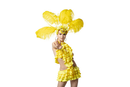 Showing. Beautiful young woman in carnival masquerade costume with yellow feathers dancing on white...
