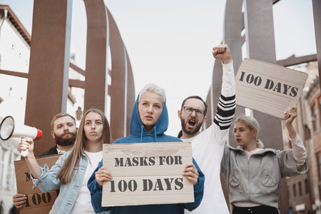 Group of activists protesting, supporting masks for 100 days in America. Look angry, hopeful, confident. Banners and smoke.の写真素材