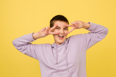 Posing cute, cheerful. Caucasian girls portrait isolated on yellow background with copyspace....