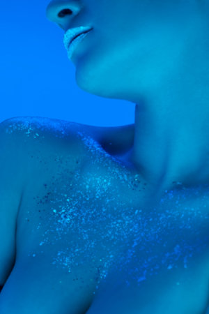 Close up female collarbones isolated on blue studio background in neon light, monochrome. Beautiful female model. Concept of human emotions, facial expression, sales, ad, fashion and beauty.の写真素材
