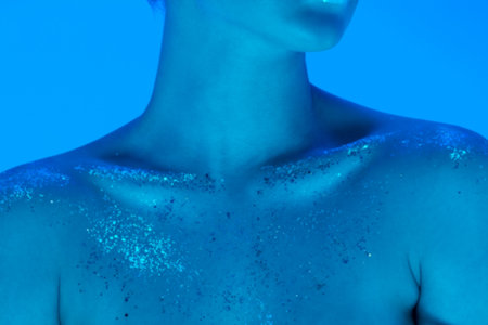 Close up female collarbones isolated on blue studio background in neon light, monochrome. Beautiful female model. Concept of human emotions, facial expression, sales, ad, fashion and beauty.の写真素材