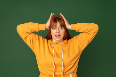 Shocked. Caucasian womans portrait isolated on green studio background with copyspace. Beautiful...
