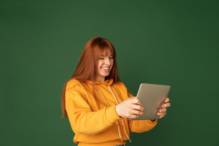 Playing excited. Caucasian womans portrait isolated on green studio background with copyspace....