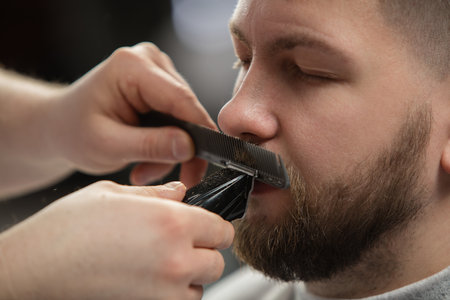 Close up of client of master barber, stylist during getting care and new look of mustache and beard....