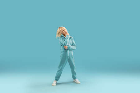 Thinking, smiling. Childhood and dream about big and famous future. Pretty curly boy isolated on blue studio background. Childhood, dreams, imagination, education, facial expression, emotions concept.の写真素材