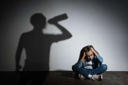 Domestic physical violence, abusing. Scared little caucasian girl, victim sitting close to white...