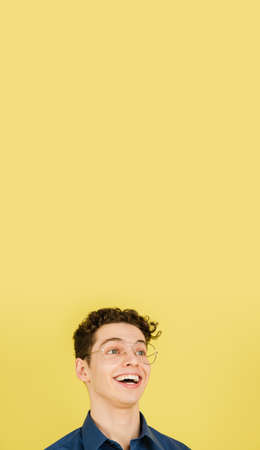 Laughting. Caucasian handsome mans portrait isolated on yellow studio background with copyspace....
