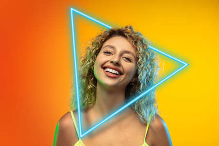 Caucasian young, attractive womans portrait isolated on gradient studio background in neon light...