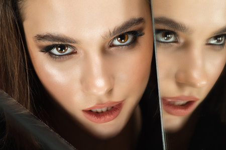 Passionate. Portrait of young female fashion model with reflection on mirrors around her face....