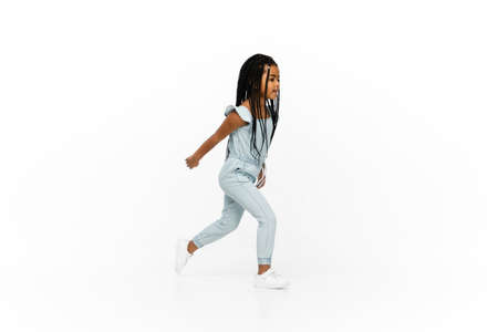 Happy longhair brunette little girl isolated on white studio background with copyspace for ad. Looks...