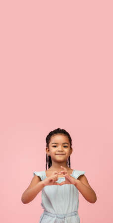 Love. Happy longhair brunette little girl isolated on pink studio background with copyspace for ad. Looks happy, cheerful, sincere. Childhood, education, human emotions, facial expression concept.の写真素材