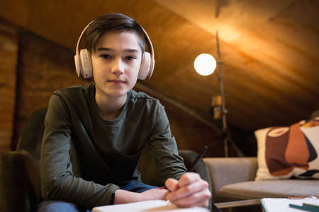 Little boy wearing headphones during online education course, lesson, view of screen. Using...