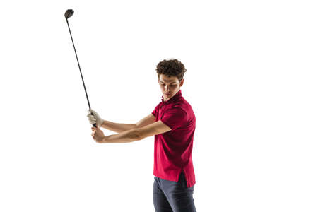 Golf player in a red shirt taking a swing isolated on white studio background with copyspace. Professional player practicing confident, emotions and facial expression. Sport, motion, action concept.の写真素材