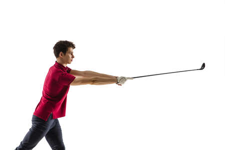Golf player in a red shirt taking a swing isolated on white studio background with copyspace....