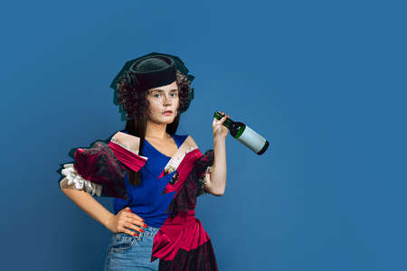 Woman with wine bottle. Magazine style collage with model outfit mixed of different eras. Copyspace...