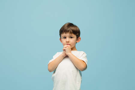 Hopeful. Happy, smiley little caucasian boy isolated on blue studio background with copyspace for ad. Looks happy, cheerful. Childhood, education, human emotions, facial expression concept.の写真素材