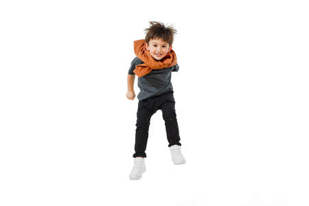 Jumping, flying. Happy, smiley little caucasian boy isolated on white studio background with...