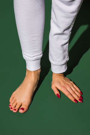 Sportive. Bright fashionable hand and leg working up daily things together. Modern artwork, contemporary art. Trendy colors, magazine style. Usual routine in unusual way. Green background.の写真素材