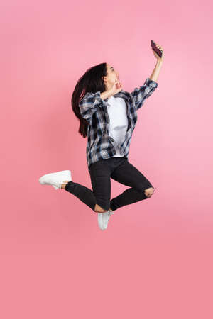 Caucasian womans portrait isolated on coral pink studio background with copyspaceの写真素材
