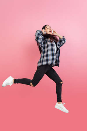 Caucasian womans portrait isolated on coral pink studio background with copyspace