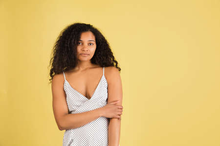 African-american woman portrait isolated on yellow studio background with copyspaceの写真素材
