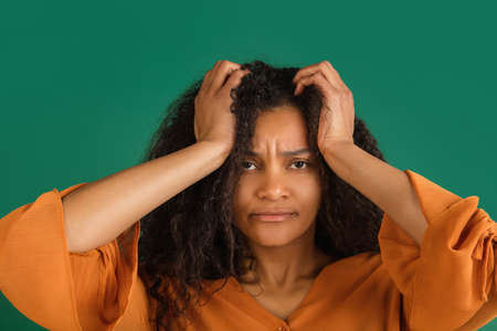 African-american woman portrait isolated on green studio background with copyspaceの写真素材