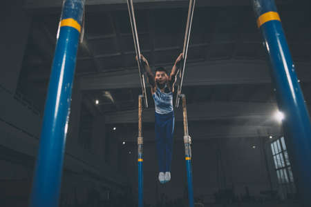 Little male gymnast training in gym, flexible and active. Caucasian fit little boy, athlete in...