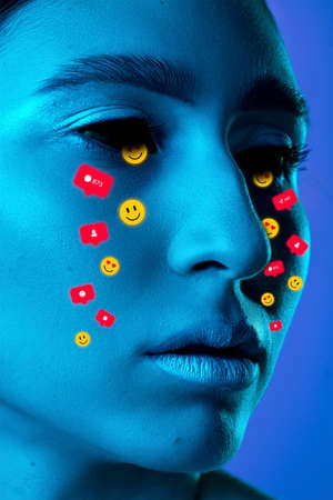 Tears illustrated of social media activity signs on female face in neon light. Real life versus online lifestyle, addiction to modern technologiesの写真素材