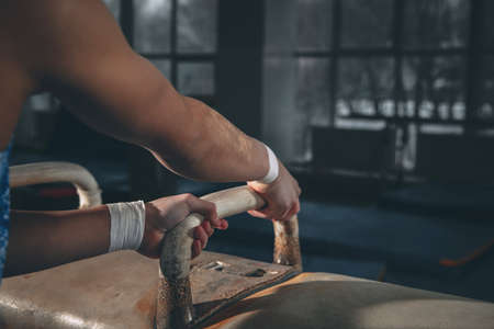 Little male gymnast training in gym, flexible and active. Caucasian fit little boy, athlete in sportswear practicing in exercises for strength, balance.の写真素材