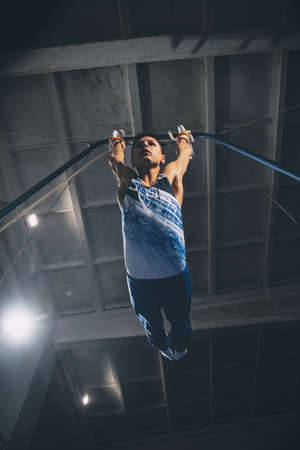 Little male gymnast training in gym, flexible and active. Caucasian fit little boy, athlete in sportswear practicing in exercises for strength, balance.の写真素材