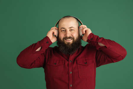 Handsome caucasian man portrait isolated on green studio background with copyspaceの写真素材